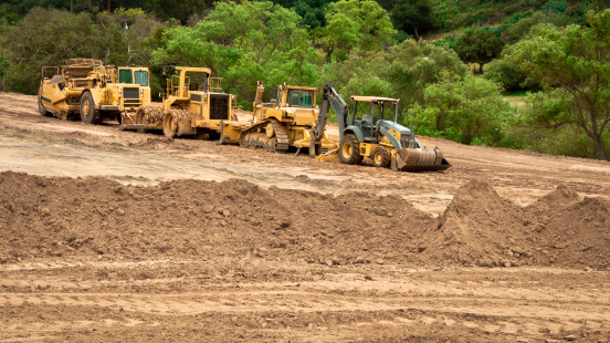 Bulldozers, graders and backhoes parked at a grading project site.
