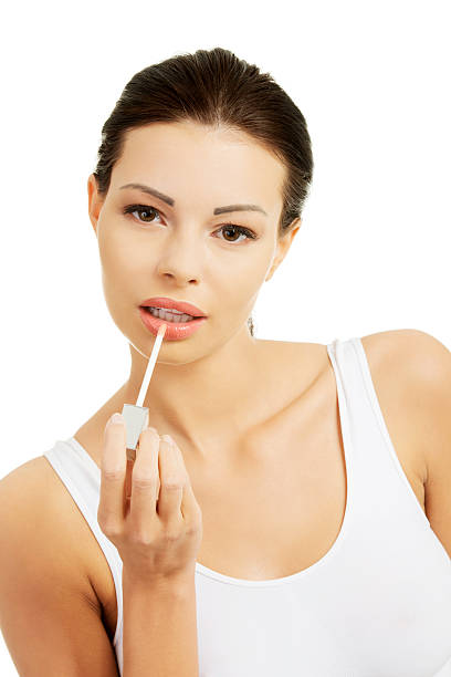 istock Beautiful woman doing her make up on lips with lipstick. 453085235