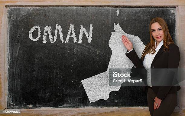 Teacher Showing Map Of Oman On Blackboard Stock Photo - Download Image Now - Adult, Beautiful People, Beauty