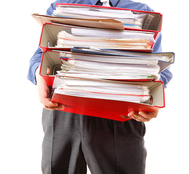 istock Male office worker carrying a stack of files 453094707