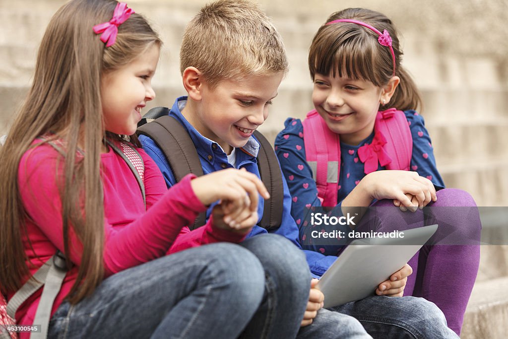 School children using digital tablet outside Learning Stock Photo