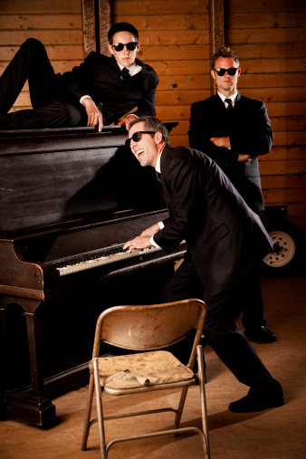 Music:  Three men in black wearing sunglasses at piano.  One singing.  Others with serious looks.  SEE MORE LIKE THIS... Similar images in lightboxes below. 