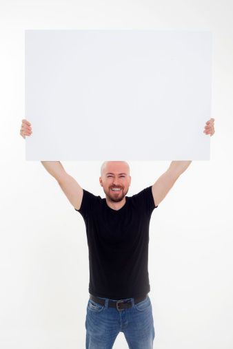 Full length portrait of a young man holding white blank card against isolated white background