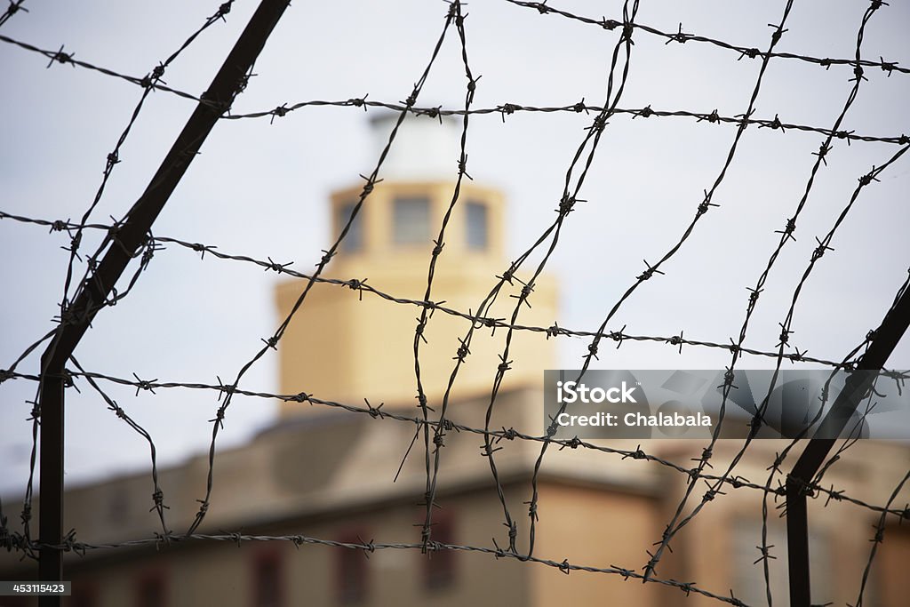 Prison Prison - barbed wire in front of the guard tower - selective focus Adversity Stock Photo