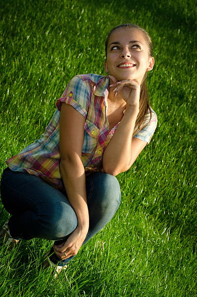 Girl sitting on a green meadow stock photo