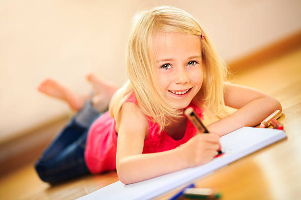 金髪の女の子に横たわるベリーの絵画 - schoolgirl little girls crayon human face ストックフォトと画像