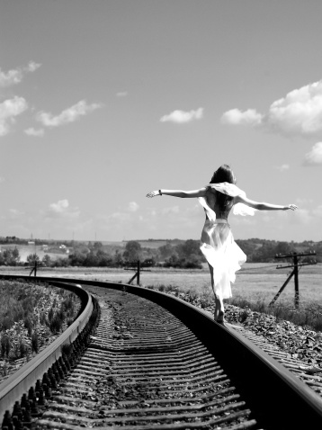 Pretty girl balancing on the railway