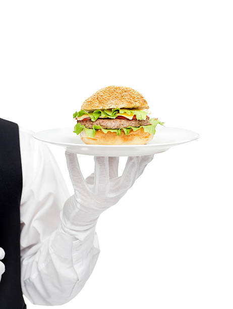 istock Waiter hand in white gloves holding hamburger on plate 453135169