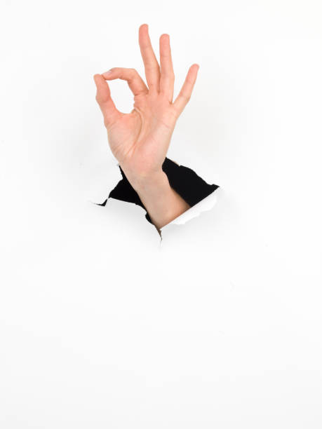 istock female hand, ok sign, paper with hole 453135621