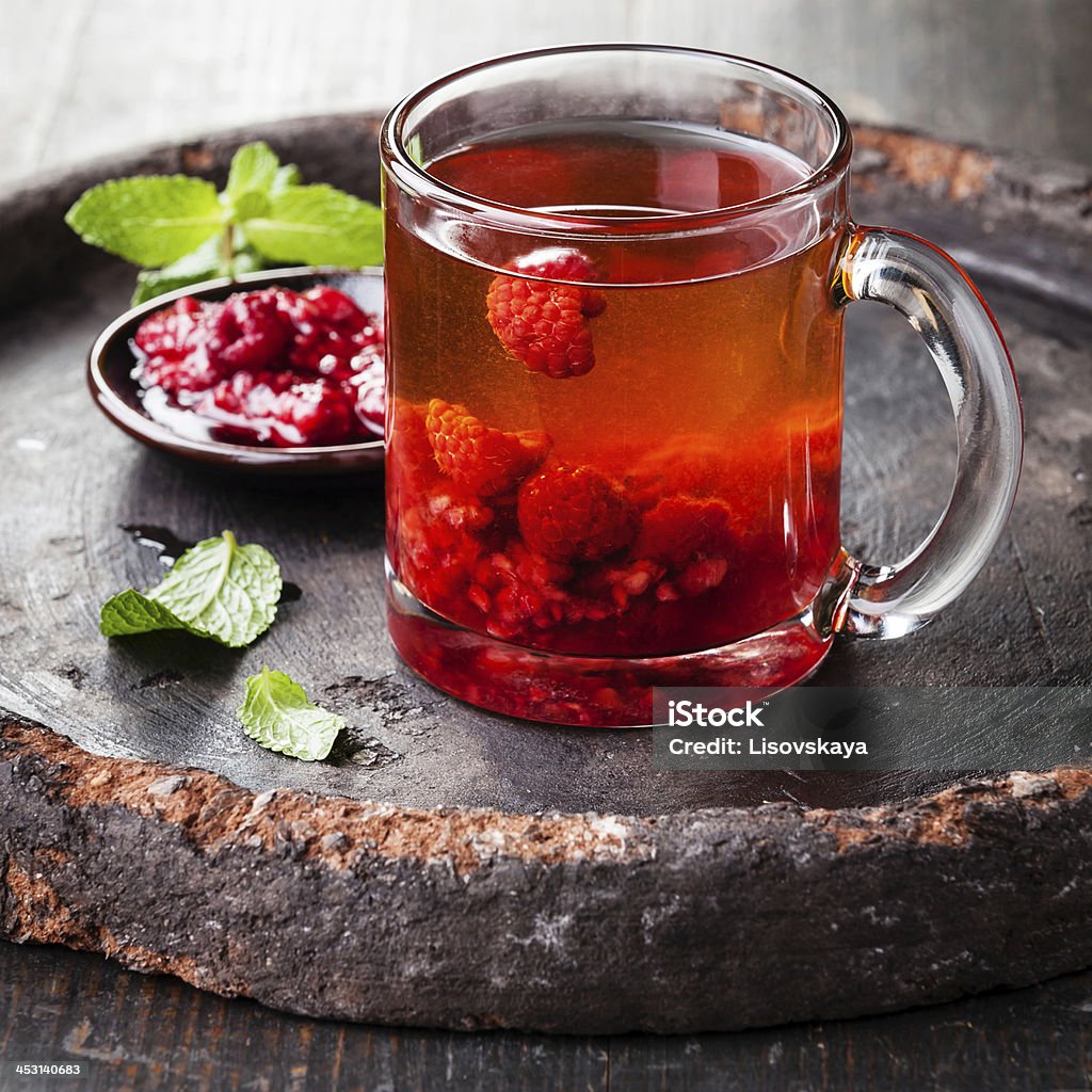 Hot tea with raspberry Hot tea with raspberry on dark background Alternative Medicine Stock Photo
