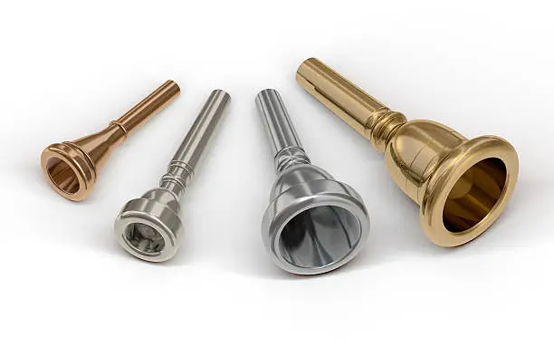 Collection of four different sized mouthpieces for brass instruments: french horn mouthpiece, trumpet mouthpiece, trombone mouthpiece, and Tuba mouthpiece, laying on a white background. The image contains clipping paths.