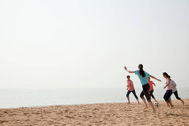 istock Young Friends Playing Soccer on the Beach 453146945
