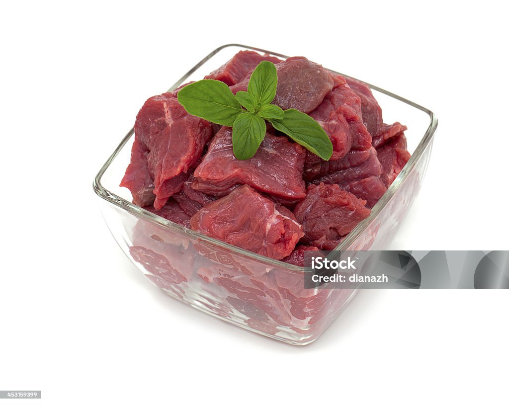 pieces of fresh beef in a glass bowl with oregano pieces of fresh beef in a glass bowl with oregano isolated on white Glass - Material Stock Photo
