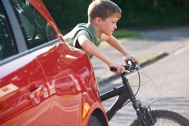 criança na bicicleta de equitação atrás de carro estacionado - child bicycle cycling danger imagens e fotografias de stock