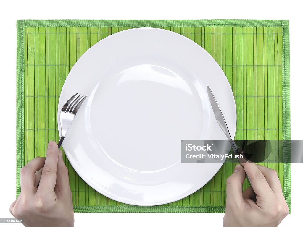 Mani tenere forchetta e coltello sopra piatto. - Foto stock royalty-free di Acciaio inossidabile