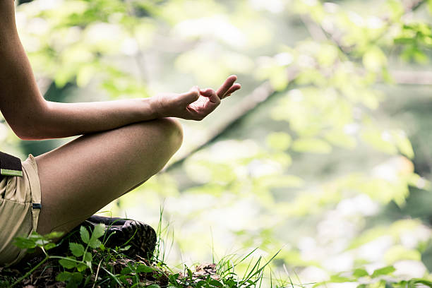 Woman enjoying nature doing yoga at the park.