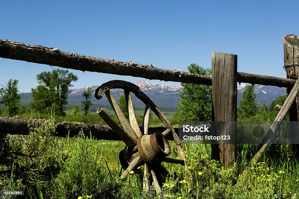 Ranch: Vecchia invecchiato Ruota di carro in legno, recinzione vissuto. - Foto stock royalty-free di Montana