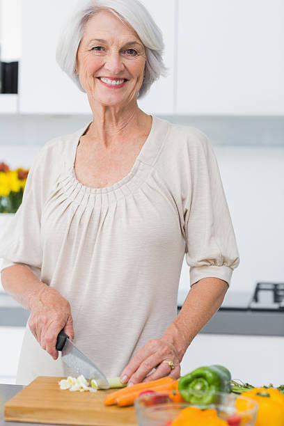 istock Happy mature woman preparing vegetables 453173513