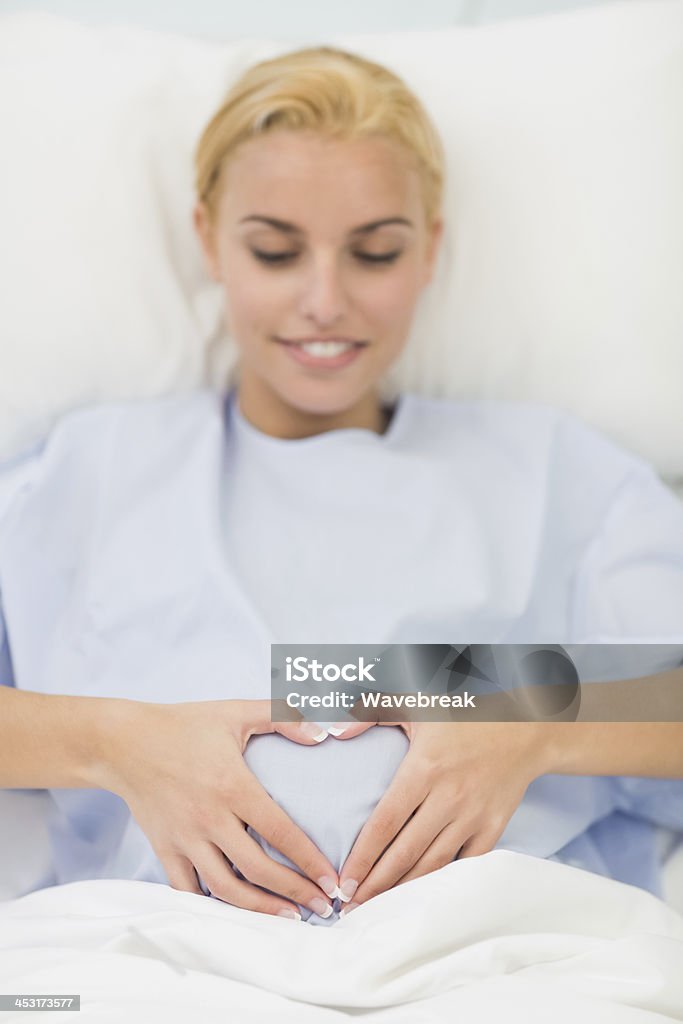 Mujer embarazada yacer en la cama - Foto de stock de 20 a 29 años libre de derechos