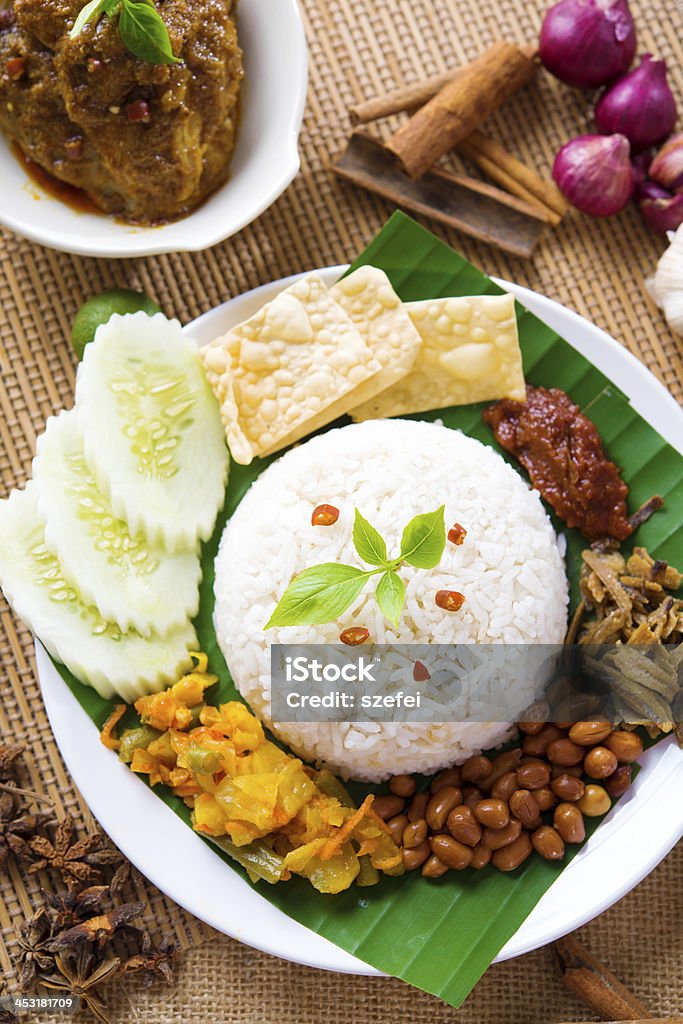 Steamed fat rice Nasi lemak kukus traditional malaysian spicy rice dish, fresh cooked with hot steam. Served with belacan, ikan bilis, acar, peanuts and cucumber. Decoration setup. Chicken Meat Stock Photo