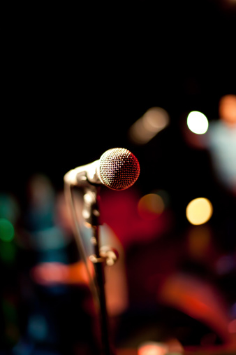 Microphone on stage with background out of focus.
