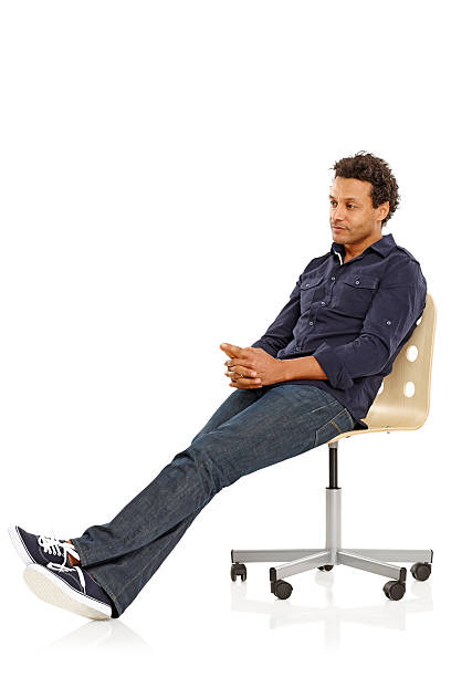 Portrait of African mature man sitting on chair thinking about something over white background