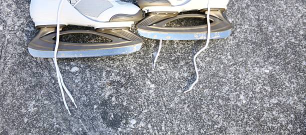 Close-up view of white figure skates resting on bench after training session at sports complex.