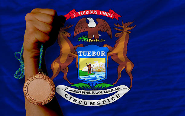 medalla de bronce de deportes estadounidense y bandera del estado de michigan - michigan football fotografías e imágenes de stock