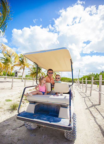 istock Back view golf cart with father and little daughters inside 453187959