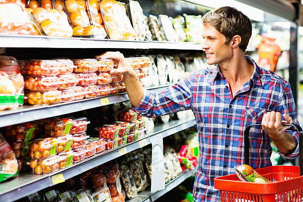 istock Man Choosing Product On Shelf While Shopping In Supermarket 453190573