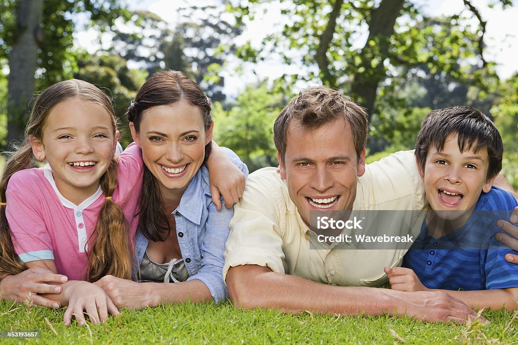 Famille rire ensemble en vous détendant dans un parc - Photo de Adulte libre de droits