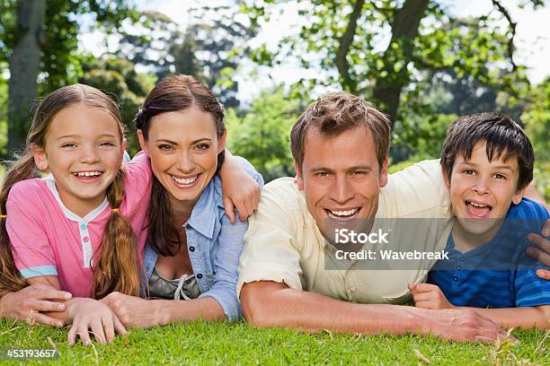 Photo libre de droit de Famille Rire Ensemble En Vous Détendant Dans Un Parc banque d'images et plus d'images libres de droit de Adulte