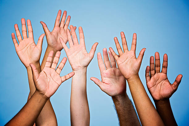 istock I'll do it! Many mixed raised hands volunteering or responding 453194231