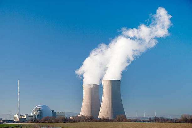 istock Nuclear power station, two steaming cooling towers, blue sky 453194681