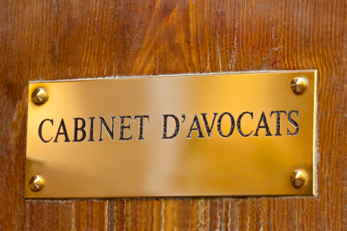 French solicitors brass sign on an old wooden door.