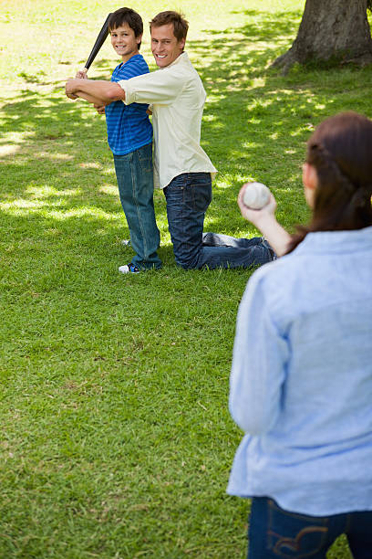 istock Happy family playing baseball in a park 453195239
