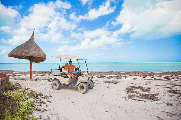 istock General view golf car with family inside on exotic beach 453196923