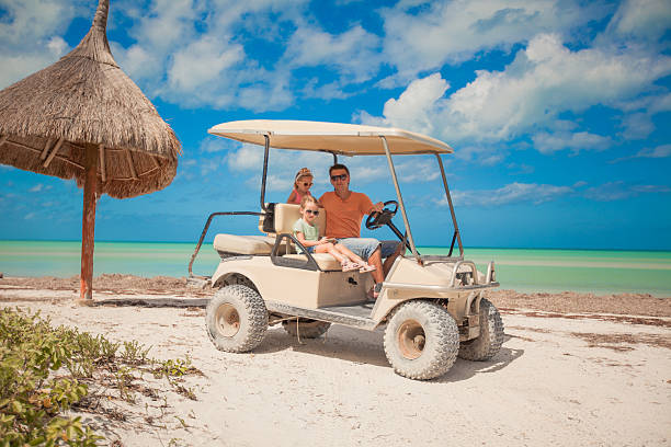 istock Dad and his daughters driving golf cart on tropical beach 453196977