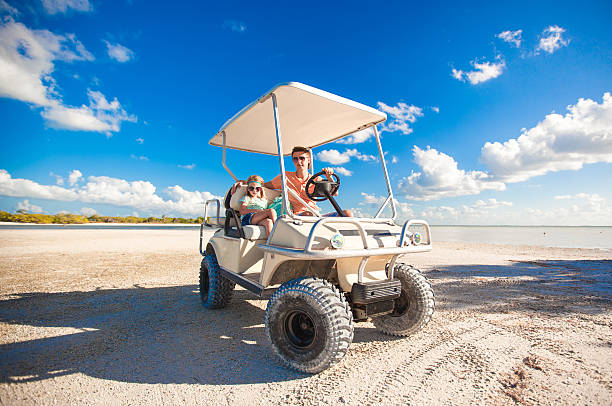 istock Dad with his daughters driving golf cart at tropical beach 453196987