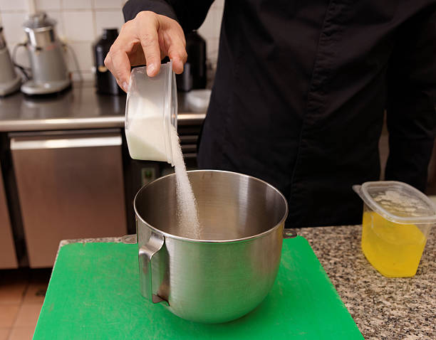 istock Pastry chef is pouring sugar in a mixing bowl 453198575