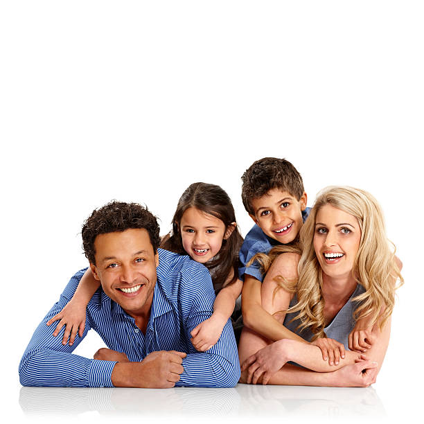 Portrait of happy mixed race family lying together on floor over white background