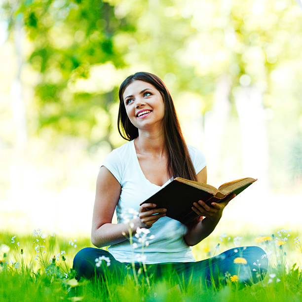 istock Woman reading book outdoors 453203793