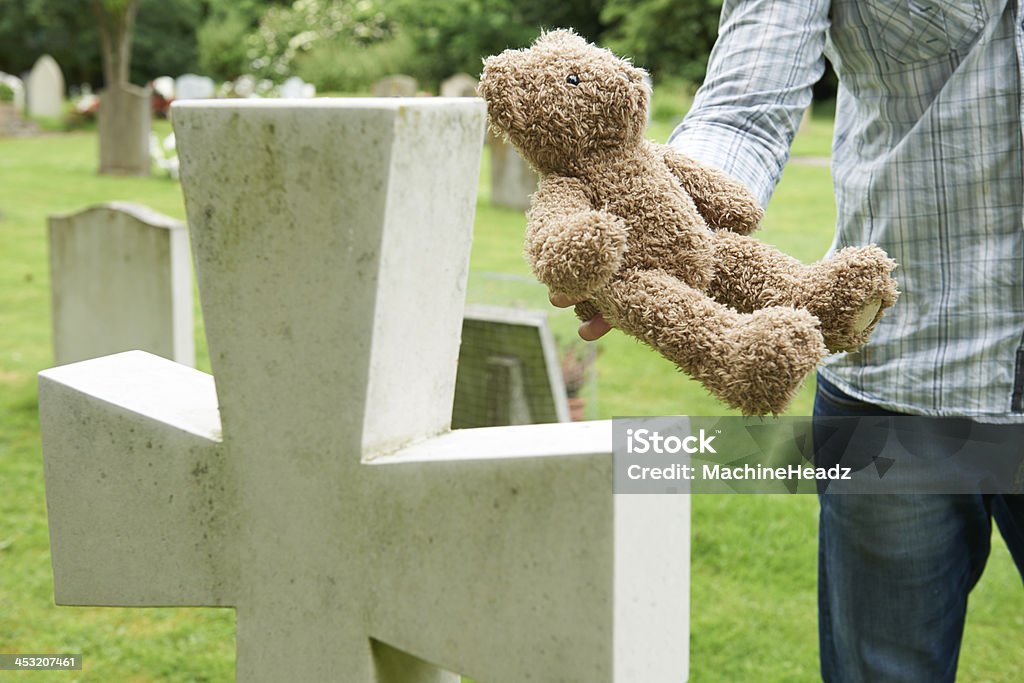 Padre colocar Osito de peluche sobre la tumba cementerio de niños - Foto de stock de Padres libre de derechos