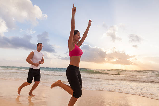 istock Fit playful couple running down the beach 453209235
