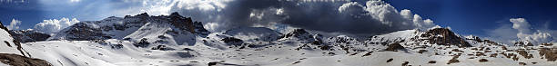 istock Panorama of snowy mountains with blue sky and dark clouds 453209465