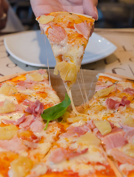 pizza in mano - human hand baked food pineapple foto e immagini stock