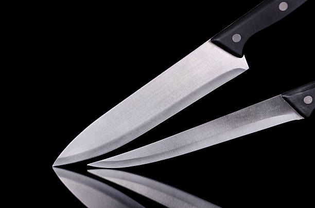 istock Close up view of two kitchen knives over black isolated 453212971