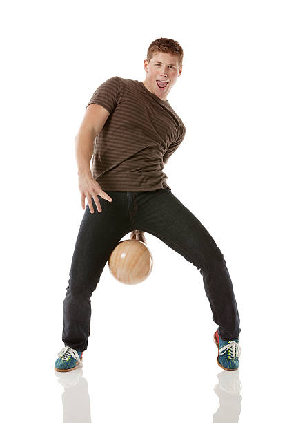 espiègle jeune homme avec une boule de bowling - bowling isolated sportsman vertical photos et images de collection