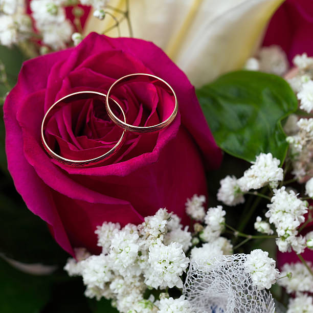 istock wedding rings  groom and bride on a bunch of flow 453217939