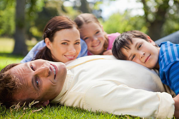 istock Smiling father lying on the grass with his family 453218187